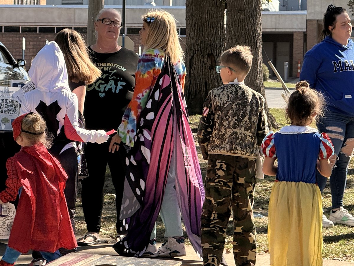 Children in costume lining up at a resource table