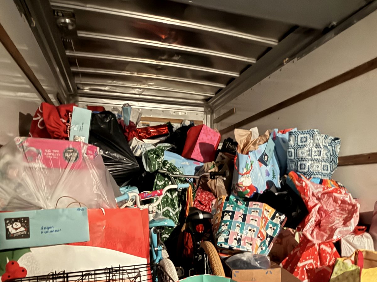A box truck packed to the roof with wrapped Christmas gifts